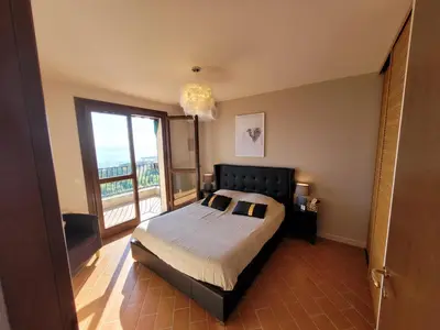 a bedroom with a bed and a large window at Superbe Villa, incroyable vue mer, avec piscine privative à Solenzara in Togna