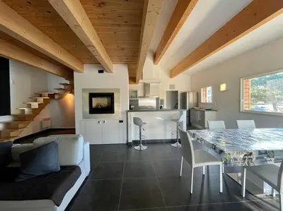 a living room with a dining table and a kitchen at APPART-SPACIEUX-VUE MER-4 PERS in Propriano