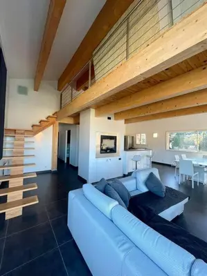 a living room with a blue couch and a staircase at APPART-SPACIEUX-VUE MER-4 PERS in Propriano