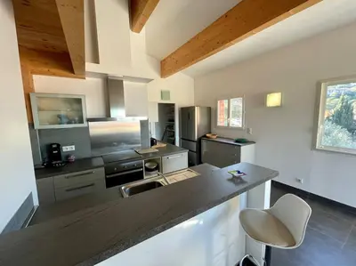 a large kitchen with a counter and a sink at APPART-SPACIEUX-VUE MER-4 PERS in Propriano