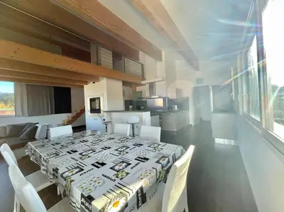 a dining room with a table and chairs and a kitchen at APPART-SPACIEUX-VUE MER-4 PERS in Propriano