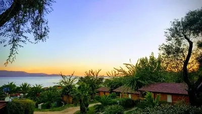 a view of the ocean from a resort at sunset at Mare E Monti Chalets in Porto Pollo