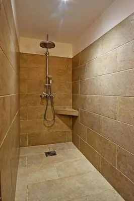 a bathroom with a shower with tiled walls at Bergeries de charme Caselle di Conca in Conca
