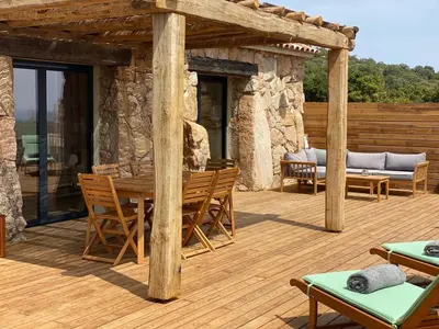 a wooden deck with a table and chairs at Bergeries de charme Caselle di Conca in Conca
