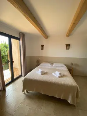a bedroom with a large bed and a large window at Bergeries de charme Caselle di Conca in Conca
