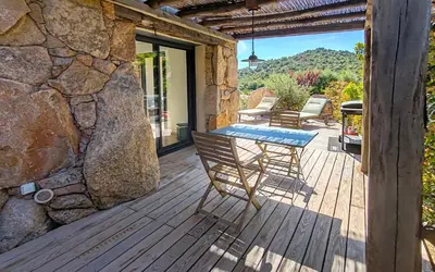 a wooden deck with a table and chairs on it at Bergeries de charme Caselle di Conca in Conca