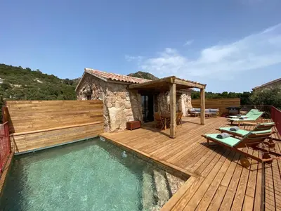 a house with a wooden deck and a swimming pool at Bergeries de charme Caselle di Conca in Conca