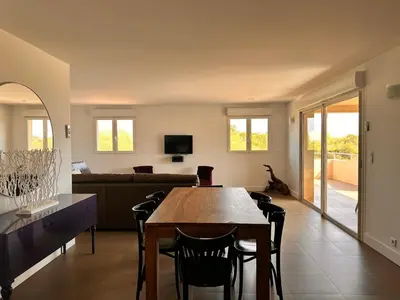 a living room with a table and a couch at ALTO DI PINARELLO in Sainte-Lucie de Porto-Vecchio