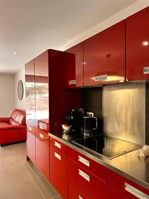 a red kitchen with red cabinets and a red couch at ALTO DI PINARELLO in Sainte-Lucie de Porto-Vecchio