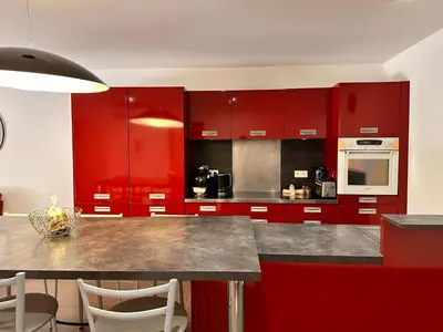 a kitchen with red cabinets and a counter top at ALTO DI PINARELLO in Sainte-Lucie de Porto-Vecchio