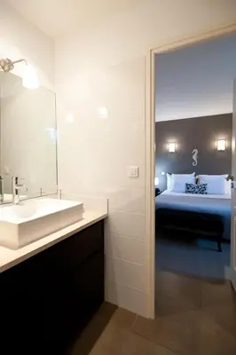 a bathroom with a sink and a bed at ALTO DI PINARELLO in Sainte-Lucie de Porto-Vecchio