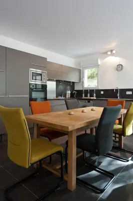 a kitchen with a wooden table and chairs at ALTO DI PINARELLO in Sainte-Lucie de Porto-Vecchio
