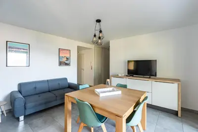 a living room with a table and a couch at L'eclat de Stagnola in Pietrosella