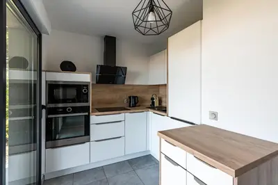 a kitchen with white cabinets and a wooden counter top at L'eclat de Stagnola in Pietrosella