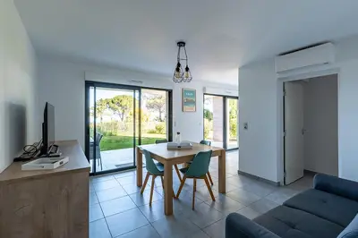 a kitchen and living room with a table and chairs at L'eclat de Stagnola in Pietrosella
