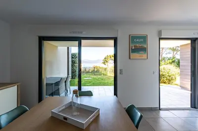 a dining room with a table and chairs and sliding glass doors at L'eclat de Stagnola in Pietrosella