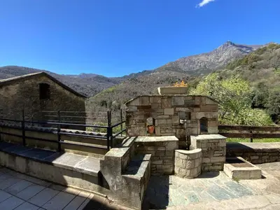 a stone building with mountains in the background at Superbe maison dans village au coeur de la Corse A casa Suttana in Verdese