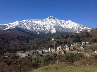 a snow covered mountain with a town on a hill at Superbe maison dans village au coeur de la Corse A casa Suttana in Verdese