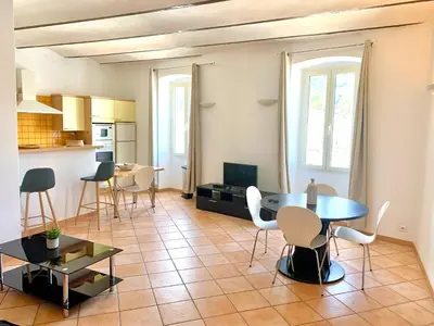 a kitchen and a living room with a table and chairs at Appartements Bonifacio AcquaViva in Bonifacio