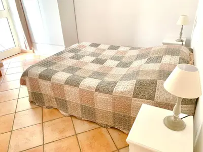 a bedroom with a bed and a lamp on a table at Appartements Bonifacio AcquaViva in Bonifacio