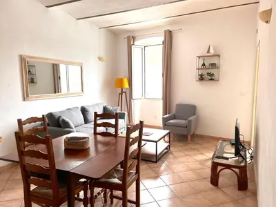 a living room with a table and a couch at Appartements Bonifacio AcquaViva in Bonifacio