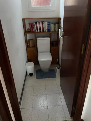 a small bathroom with a toilet with a book shelf at Villa près de la Plage in Grosseto-Prugna