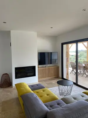 a living room with a couch and a tv at Villa de charme avec piscine à Ajaccio in Alata