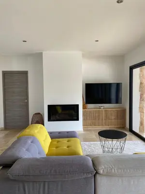 a living room with a couch and a tv at Villa de charme avec piscine à Ajaccio in Alata