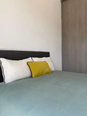 a bed with a yellow pillow on top of it at Villa de charme avec piscine à Ajaccio in Alata