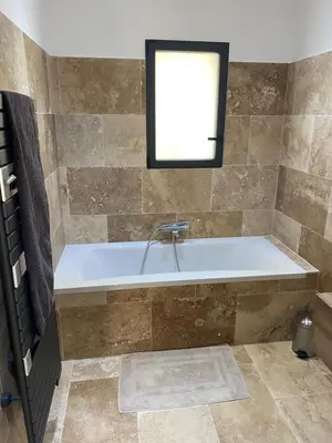 a bath tub in a bathroom with a window at Villa de charme avec piscine à Ajaccio in Alata
