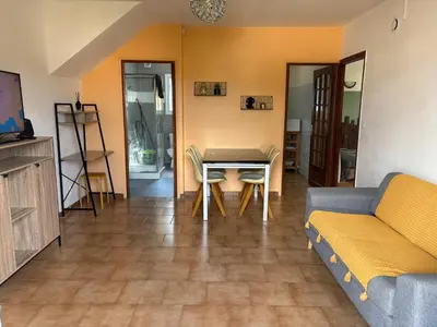 a living room with a table and a couch at Joli T2 dans villa in Corte
