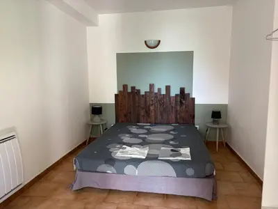 a bedroom with a bed and two tables at Joli T2 dans villa in Corte