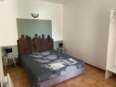 a bedroom with a bed in a room with two tables at Joli T2 dans villa in Corte