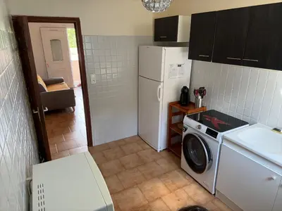 a kitchen with a refrigerator and a washing machine at Joli T2 dans villa in Corte