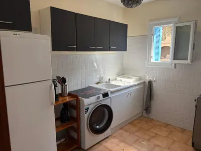 a kitchen with a washing machine and a sink at Joli T2 dans villa in Corte