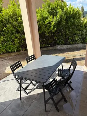 a black table and chairs on a patio at Joli T2 dans villa in Corte
