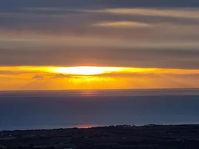 a sunset over the ocean with the sun setting at Casa Di Vadella in Santʼ Andrea-di-Cotone