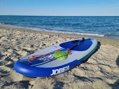 a surfboard sitting on the sand on the beach at Casa Di Vadella in Santʼ Andrea-di-Cotone
