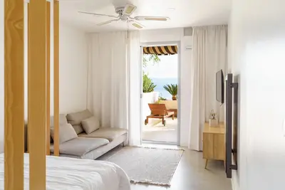 a bedroom with a bed and a couch and a patio at Destinu Marinella in Ajaccio