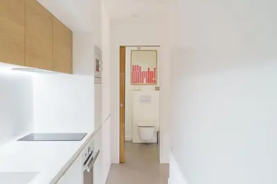 a white bathroom with a toilet and a hallway at Destinu Marinella in Ajaccio