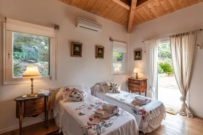 two beds in a room with two windows and a lamp at Villa Pol & Dod - Piscine et vue sublime in Monacia-dʼAullène