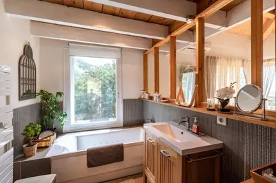 a bathroom with a tub and a sink and a window at Villa Pol & Dod - Piscine et vue sublime in Monacia-dʼAullène