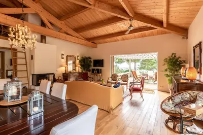 a living room with a wooden ceiling and a table at Villa Pol & Dod - Piscine et vue sublime in Monacia-dʼAullène