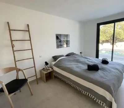 a bedroom with a bed and a ladder and a chair at Villa Pura Vida Di Olmuccio in Sainte-Lucie de Porto-Vecchio