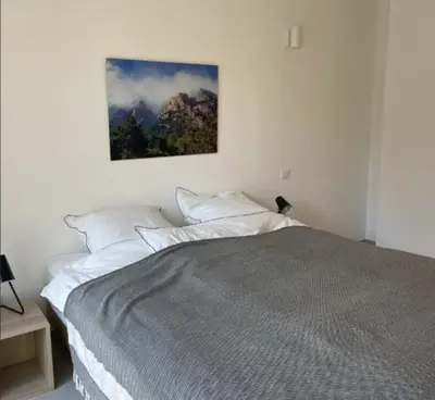 a bedroom with a bed with a picture on the wall at Villa Pura Vida Di Olmuccio in Sainte-Lucie de Porto-Vecchio