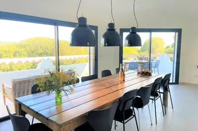 a dining room with a wooden table and chairs at Villa Pura Vida Di Olmuccio in Sainte-Lucie de Porto-Vecchio