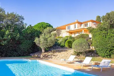 a house with a swimming pool with chairs and a house at Villa Clementina Di Punta d'Arasu in Sainte-Lucie de Porto-Vecchio