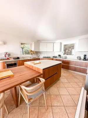 a kitchen with a wooden table and a counter at Villa Clementina Di Punta d'Arasu in Sainte-Lucie de Porto-Vecchio