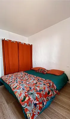 a bedroom with a bed with a colorful comforter at Appartement Vue mer en plein centre de Cargese in Cargèse