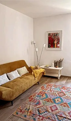 a living room with a couch and a rug at Appartement Vue mer en plein centre de Cargese in Cargèse